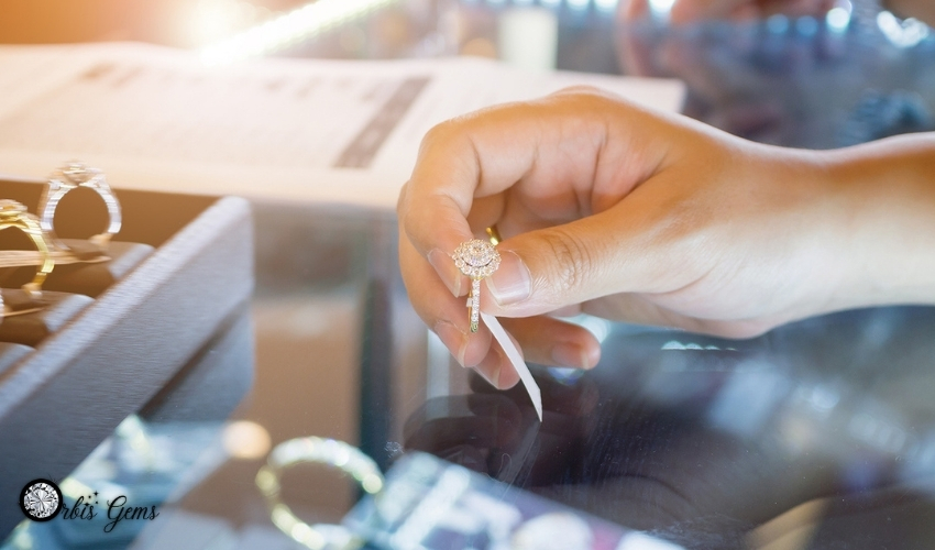 A hand evaluating a delicate moissanite ring, highlighting the beauty and ethical advantages suggesting moissanite is better than diamond.